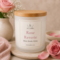 Arc Candles 'Rose Reverie' soy candle in a frosted glass jar with a light wood lid, styled on a wooden tray with pink roses and a pink towel.